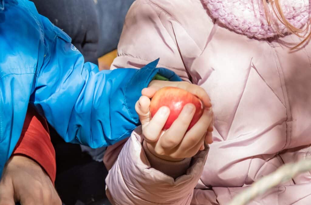 children share an apple faceless portrait