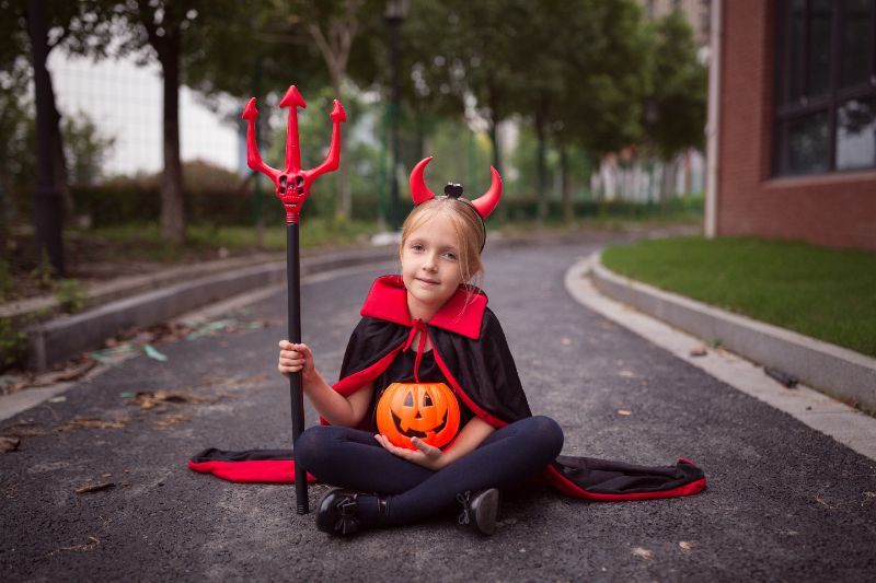 little girl in halloween costume of devil