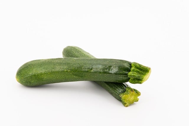 one zucchini on top of another one on a white background.